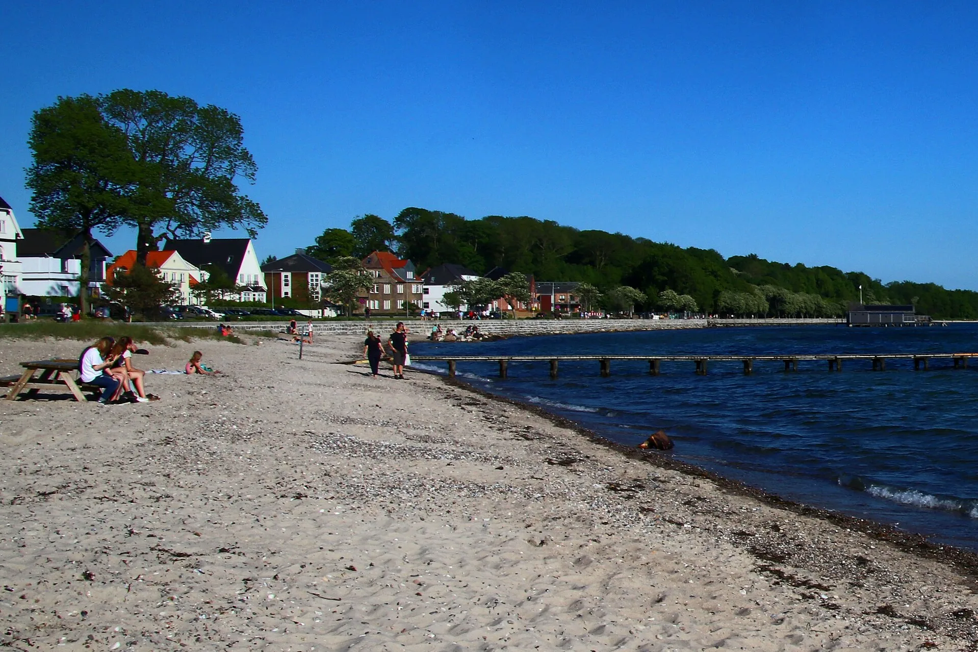 Sandstrand Fluepapiret in Sønderborg mit Badesteg und Yachthafen im Hintergrund